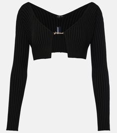 a cropped black sweater with an open front and zippers on the chest,