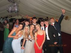 a group of young people standing next to each other in front of a white tent