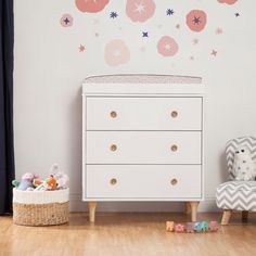 a white dresser sitting next to a wall with stars on it