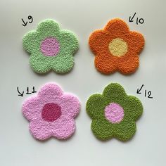 four flower appliques are shown in three different colors, one is pink, one is green and the other is orange