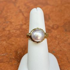 New, but old pieces, never worn, recently acquired from a premier jeweler located in Minneapolis, MN for many years- A rare opportunity! 14KT yellow gold genuine, bezel-set, Mabe pearl ring with Etruscan/ filigree design. Size 6.25 Sizable by us for a fee or your local jeweler Weight: 7.90 grams Band width: 4mm 11mm pearl Stamped 14k Oval Yellow Gold Pearl Ring With High Luster, Oval Pearl Ring In Yellow Gold With High Luster, Elegant Cabochon Rings For Anniversary, Heirloom High Luster Oval Pearl Ring, Classic Cabochon Pearl Ring For Formal Occasions, Luxury Yellow Gold Pearl Ring With Cabochon, Classic Oval Ring With High Luster, Classic Formal Pearl Ring With Cabochon, Classic Oval Rings With High Luster