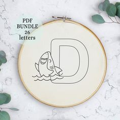 a hand embroidery pattern with the letter d in black and white, on a marble surface