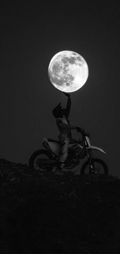 a person on a motorcycle with the moon in the background