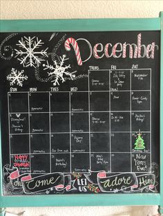 a chalkboard calendar hanging on the wall with christmas decorations and candy canes attached to it