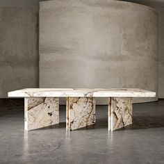 a marble table sitting in front of a concrete wall with three columns on each side