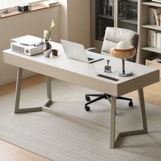 an office desk with a laptop on it in front of a bookcase and bookshelf