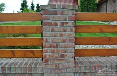 a brick wall with a wooden fence in the background