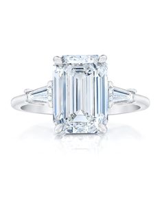 an emerald - cut diamond ring with three baguets on the shoulders and side stones