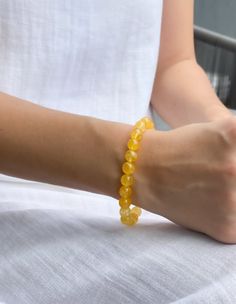 This unique citrine bracelet is the perfect way to access the power of this amazing stone. Citrine has been used for centuries to promote happiness, abundance, and success. This beaded bracelet is created with a stretchy band for a comfortable fit. Amber Citrine Bracelet With Gemstone Beads, Amber Round Beads Bracelet For Meditation, Amber Beaded Bracelets For Meditation, Hand-strung Amber Beaded Bracelets For Meditation, Adjustable Yellow Citrine Crystal Bracelet, Yellow Citrine Spiritual Bracelets, Yellow Spiritual Crystal Bracelet, Spiritual Citrine Round Bead Bracelets, Amber Citrine Beaded Bracelets As A Gift