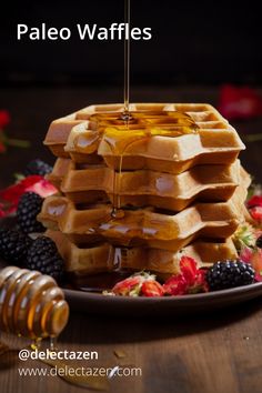 a stack of waffles on a plate with honey drizzled over them