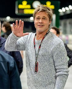 a man is making the peace sign with his hand while standing in front of other people