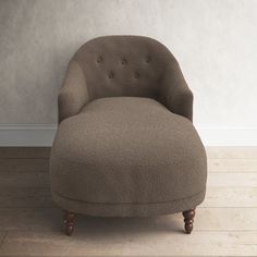 a brown chair sitting on top of a hard wood floor next to a white wall