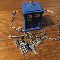 a blue police box and keychain on a wooden table next to a chain