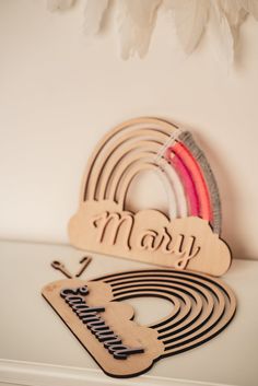 a wooden sign that says mary and rainbows on it next to a white wall