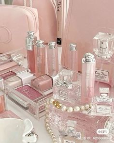 a table topped with lots of pink perfume bottles