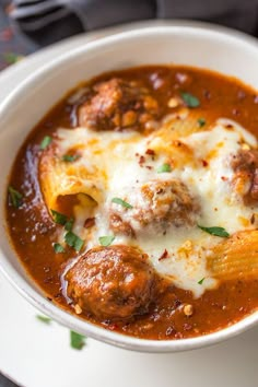 a white bowl filled with meatballs and cheese