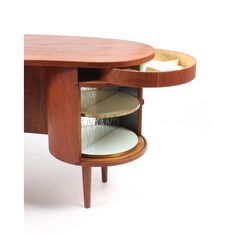 an oval shaped wooden table with two circular shelves in the middle and one section open