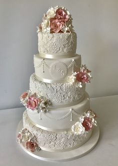 a three tiered wedding cake with pink and white flowers