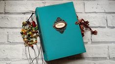 a blue book sitting on top of a white brick wall next to a bunch of colorful beads