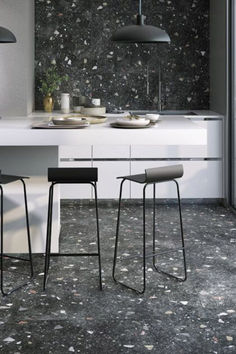 Black Terrazzo Floor and Wall Tiles in a Kitchen Showing A White Island with Two Black Stools with a Low Bowl Ceiling Light Terrazzo Wall, Moody Design