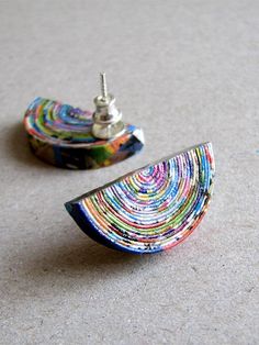 there are two pairs of colorful earrings on the floor next to each other and one has a silver earring