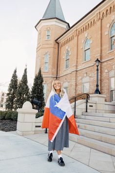 a woman holding a flag in front of a building