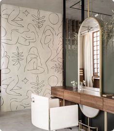 a mirror sitting on top of a wooden table next to a vanity with a stool