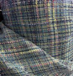 an up close shot of a colorful plaid fabric on a chair with the seat down