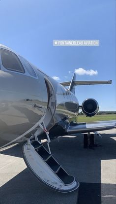 an airplane sitting on the tarmac with its door open