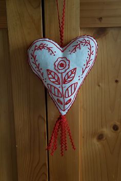 a red and white heart hanging from a wooden door