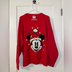 a red mickey mouse sweater hanging on a door