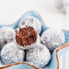 chocolate truffles in a blue bowl with powdered sugar on top