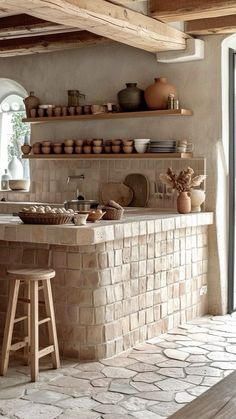 a kitchen with stone counters and shelves filled with pots, pans and bowls on top of the counter