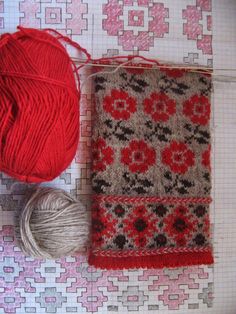 a red ball of yarn sitting on top of a table next to some balls of yarn