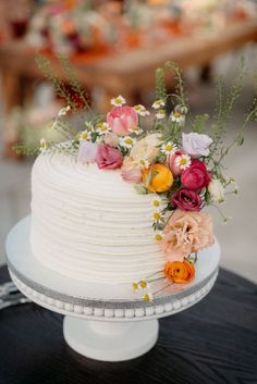 a white wedding cake with flowers on top