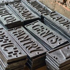 several metal signs are stacked on top of each other in front of a brick wall