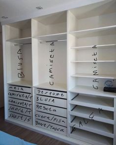 an empty white closet with drawers and writing on the wall next to it's doors