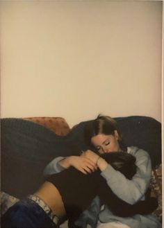 two people sitting on a couch hugging each other