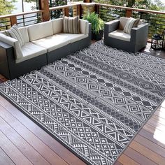 a black and white area rug sitting on top of a wooden floor next to two couches