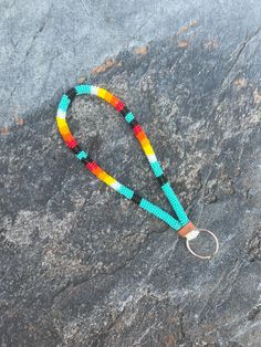 a multicolored beaded lanyard on a rock