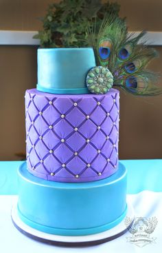 a purple and blue cake with peacock feathers on top