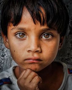 a young boy is looking at the camera