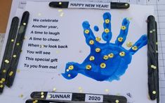 a blue handprint with yellow buttons on it and some black scissors next to it