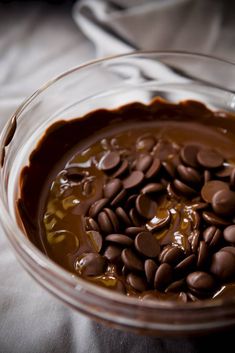 a glass bowl filled with chocolate chips on top of a table