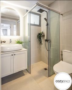 a bathroom with a toilet, sink and shower stall in the middle of the room