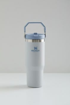 a white and blue insulated cup sitting on top of a table