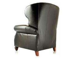 a black leather chair sitting on top of a white floor next to a wooden leg