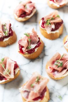 small appetizers with cranberry sauce and prosciutto on top