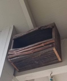 a wooden box hanging from the side of a building