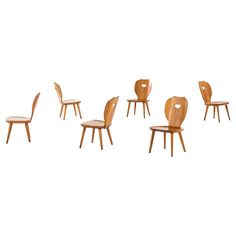 six wooden chairs in various positions on a white background with one chair facing the other